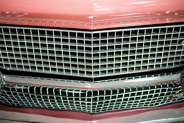 chrome radiator grille of retro racing car close-up with blurred background