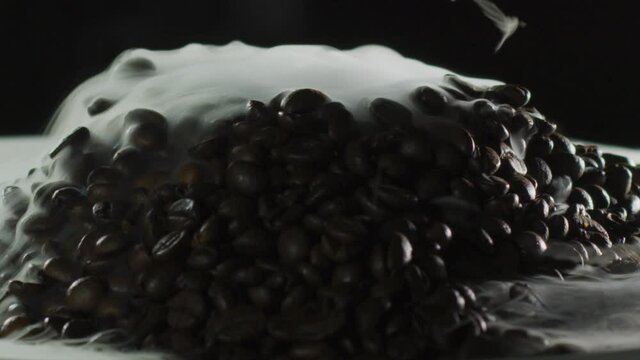 Smoking volcano made of roasted coffee beans, conceptual slow motion shot