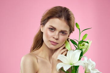 Beautiful woman bouquet flowers cosmetics naked shoulders pink background