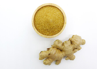 Finely ground dry Ginger powder in wooden bowl with Rhizomes (root) and sliced isolated on white background