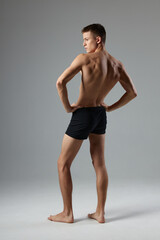 Fototapeta na wymiar sporty man with pumped up body black shorts back view isolated background