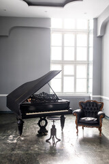 black antique grand piano in the interior with beautiful light from the window