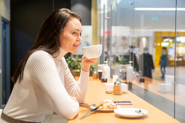 beautiful woman drinking coffee at a bar in a cafe