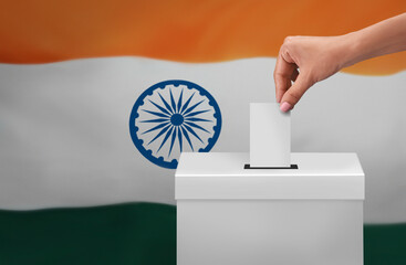female or women Voter Holds Envelope In her  Hand Above Vote Ballot for casting vote on India flag...