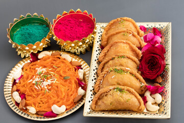 Indian Festival Happy Holi Celebration With Delicious Gujia Or Gujiya Mithai Jalebi Ghewar Dry Fruits And Colorful Gulal Abeer Or Abir Isolated On Grey Background