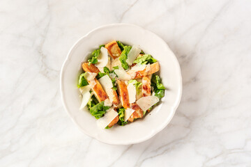 Caesar salad with grilled chicken meat, green romaine salad and Parmesan cheese, top shot