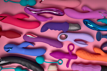 top view on colourful Dildo vibrators for sex games isolated on pink background. Sex toy for adult....