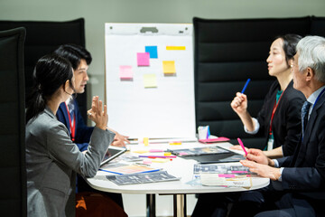 会話をしながら企画会議を進める社内の同僚たち