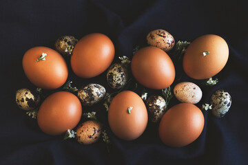 Easter eggs and spring flowers on dark blue natural cloth. Easter stylish composition. Top view, flat lay