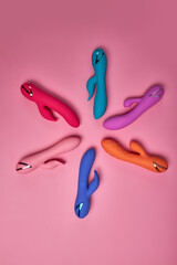 Stimulate Your Most Sensitive Area. Composition Of Colorful G-spot Vibrators Arranged On Pink Paper Background. View From Above. Place For Text. Flat Lay. Sex Shop Concept.