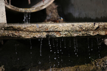 drops of water flowing down from a concrete slab