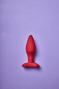 small red butt plug, sex toy for adult, designed anal plug isolated on purple background. minimal concept. sex concept