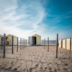 Türaufkleber Vintage yellow and white beach hut against blue sky. © Erik_AJV