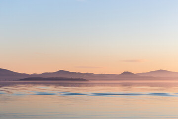 Sunset on Trasimeno lake (Umbria, Italy), with empty sky and beautiful water reflections