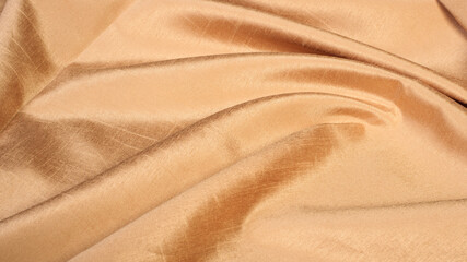Fototapeta na wymiar Bends, waves, folds of gold, shiny satin fabric, abstract background for the holiday