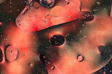 Oil bubbles on water abstract form in glass tank.