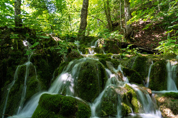 Waterfall with turquoise water in the Plitvice Lakes National Park, Croatia.