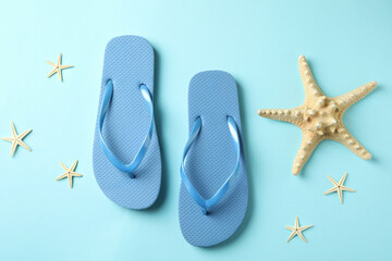 Flip flops and sea stars on blue background