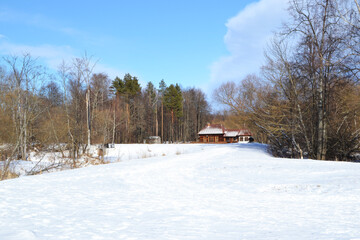Fototapeta na wymiar Old small wooden house in the winter forest in sunny weather