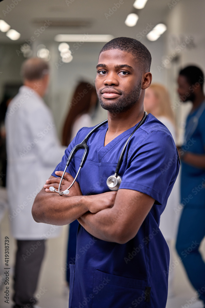 Wall mural portrait of pleasant kind medical worker of african appearance , young handsome afro american male d