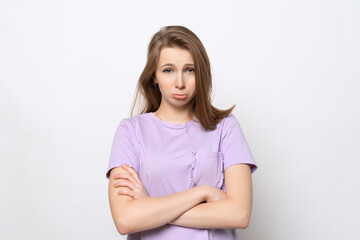 Fototapeta premium Sad girl standing alone feeling upset, frustrated and disappointed, looking at camera, has innocent expression