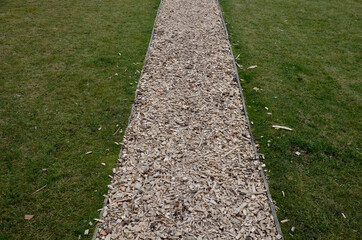 park path in the outdoor fitness training center. The soft surface of the narrow jogging path is...