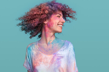 Playful hipster woman with Holi paint having fun