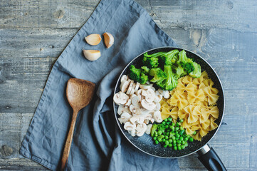 ingredients for cooking tasty one pot italian pasta with broccoli, mushrooms, sweet beans in creamy sauce