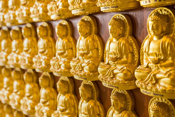 Nonthaburi, Thailand- March 08, 2021 : Many golden buddha statues arrange by row and column at the wall in the temple in Leng Noei Yi 2 or Mangkon Temple in Nonthaburi