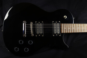 Fototapeta na wymiar Black electric guitar on dark background