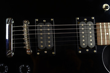 Electric guitar details close up on black background