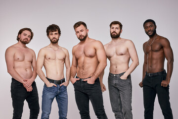 Interracial group of young shirtless men posing seriously at camera, sexy guys in jeans having muscular body, fit and strong. people, models, fashion, masculinity concept