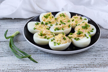 stuffed eggs with crab sticks, mayonnaise and green onion on black plate © dashtik
