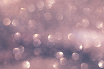 Pink bokeh on a light background. Glitters and rhinestones sparkling in the rays of light.