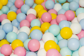 Fototapeta na wymiar many small colorful plastic balls in the pool Children's playroom, pink, yellow, Blue, white