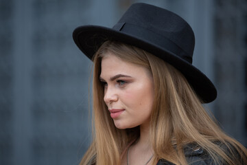 Blonde girl in hat and ferris wheel in modern city
