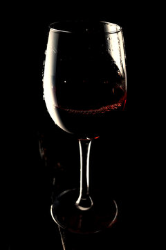 Red wine in glass on dark old board