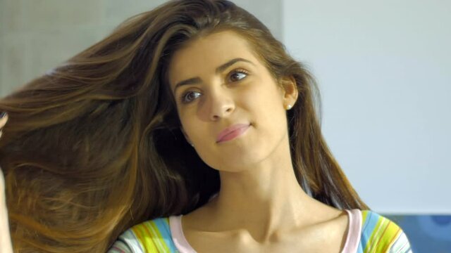 Woman undoing from bun long hair slow motion looking camera smiling slow motion