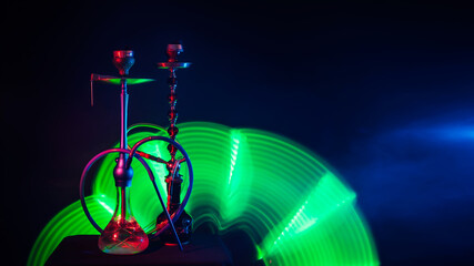 metal hookahs with glass flasks with shisha charcoals in smoke