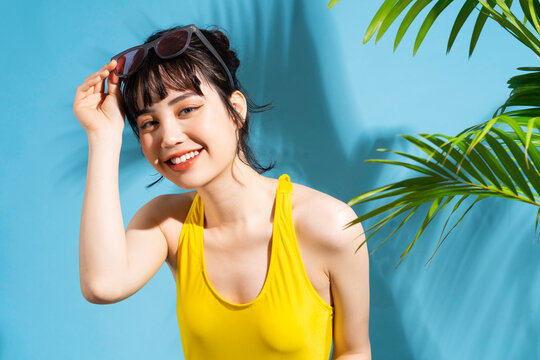 Beautiful Asian woman wearing yellow jumpsuit on blue background and, summer concept