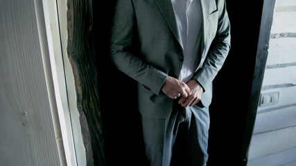 a man in a suit stands near the door - Powered by Adobe