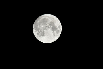 Detailed closeup shot of a beautiful full moon isolated on the black background