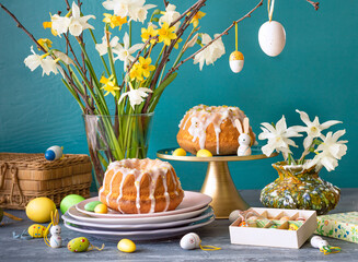 Obraz na płótnie Canvas Easter decoration table with cake eggs flowers daffodiles 