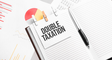 text DOUBLE TAXATION on stickers on the diary with office tools