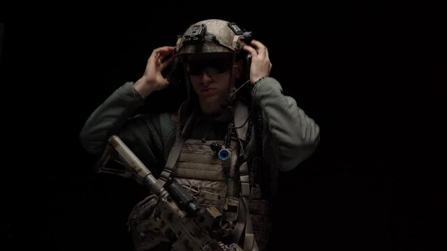 Special forces US soldier puts on his helmet in the dark