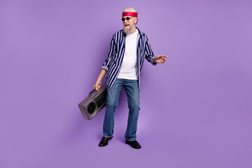 Full body photo of aged crazy man happy positive smile hold boombox retro music dance isolated over violet color background