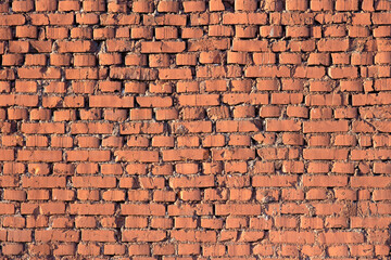 Old cracked uneven brick wall. Colorful texture background