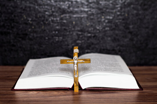 Bible with a cross on a wooden table. Prayer.
