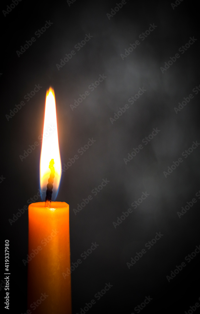 Wall mural Candle on a dark background. Sorrow. Death.