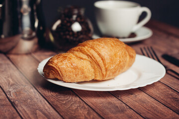 croissants saucer on the table fork with a knife fresh pastries